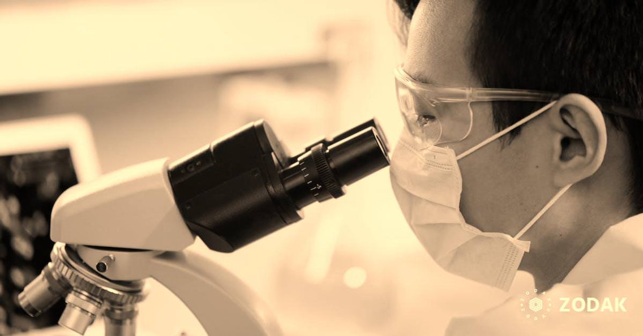 Man Looking Through A Microscope