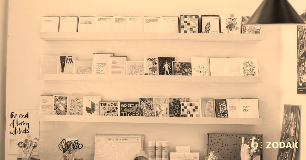 Interior of modern light shop with wooden shelves with various books and stationery composed with creative decorative elements