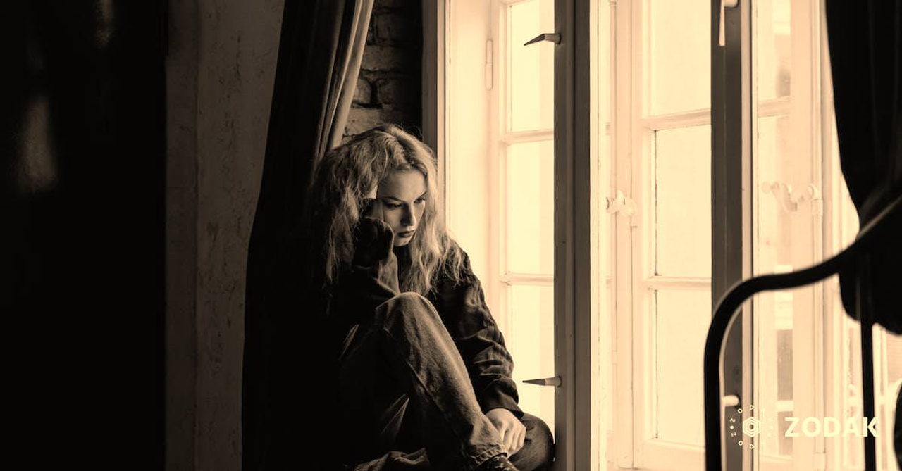 Woman in Black Leather Jacket Sitting on Brown Wooden Floor