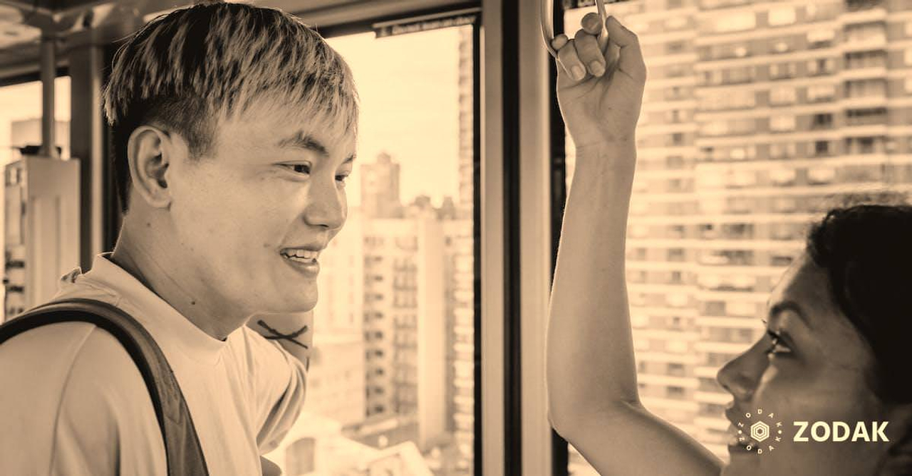 Happy Asian couple riding ropeway cabin in modern city