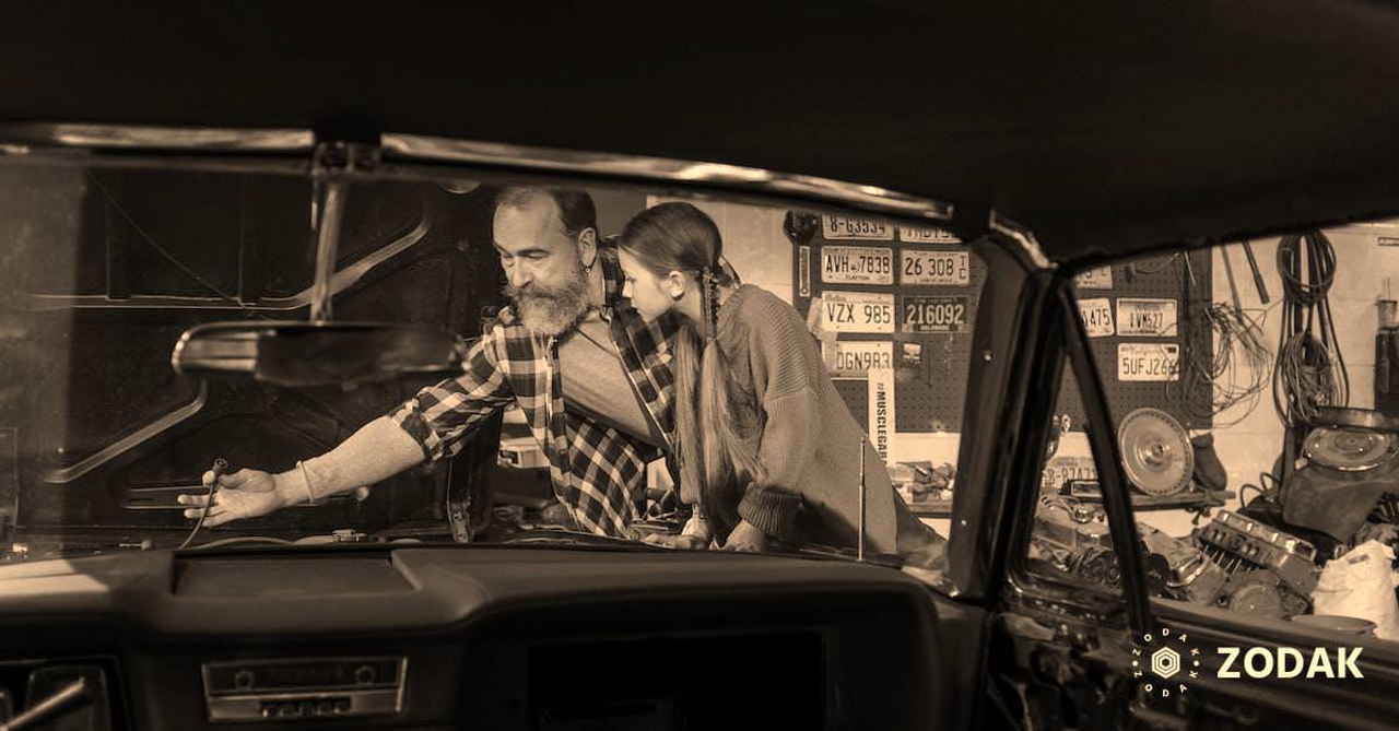 A Mechanic Teaching his Daughter How to Fix a Car