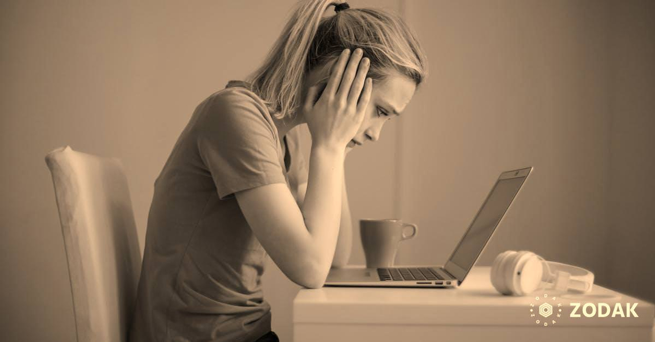 Young troubled woman using laptop at home