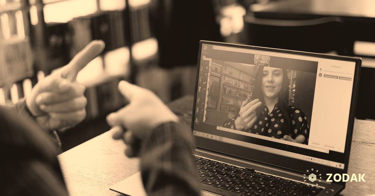 Young lady learning sign language during online lesson with female tutor