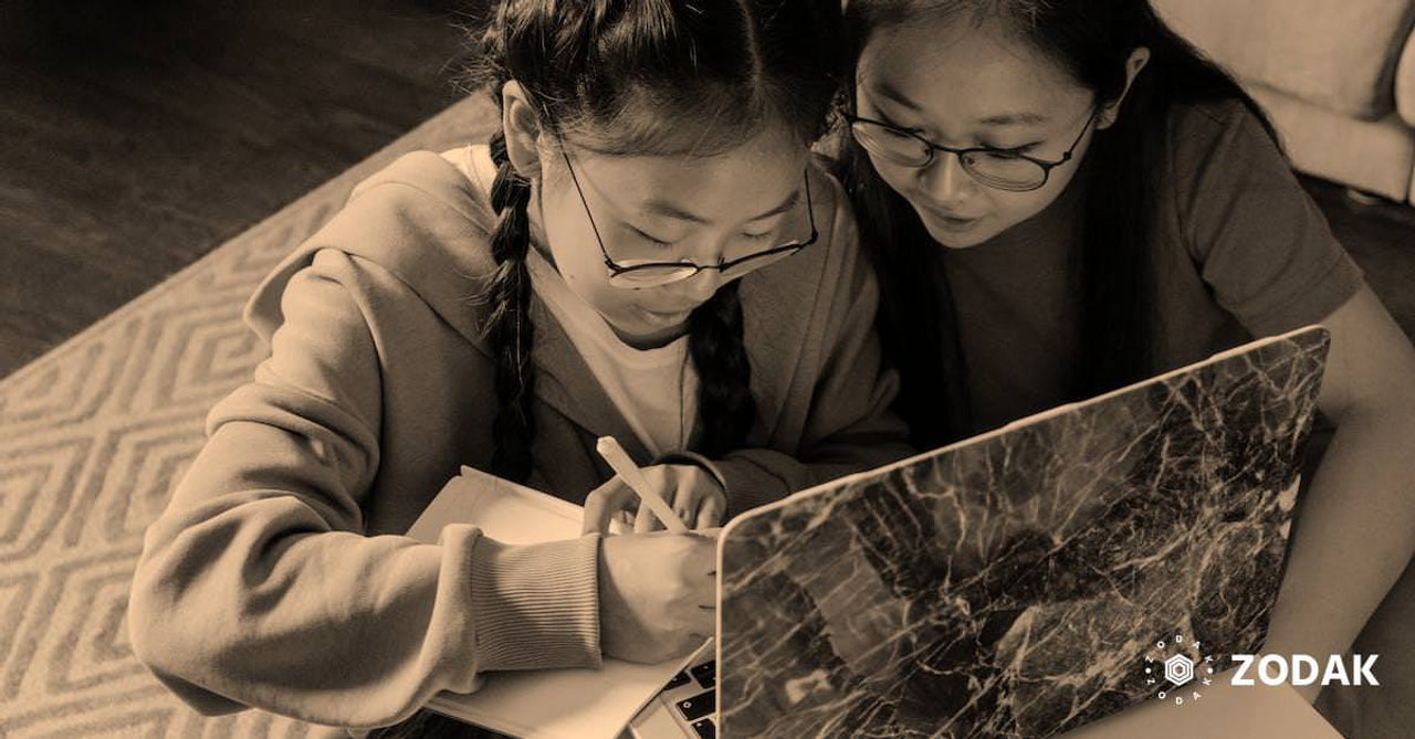 Girls Wearing Eyeglasses Having Conversation while Writing on a Notebook