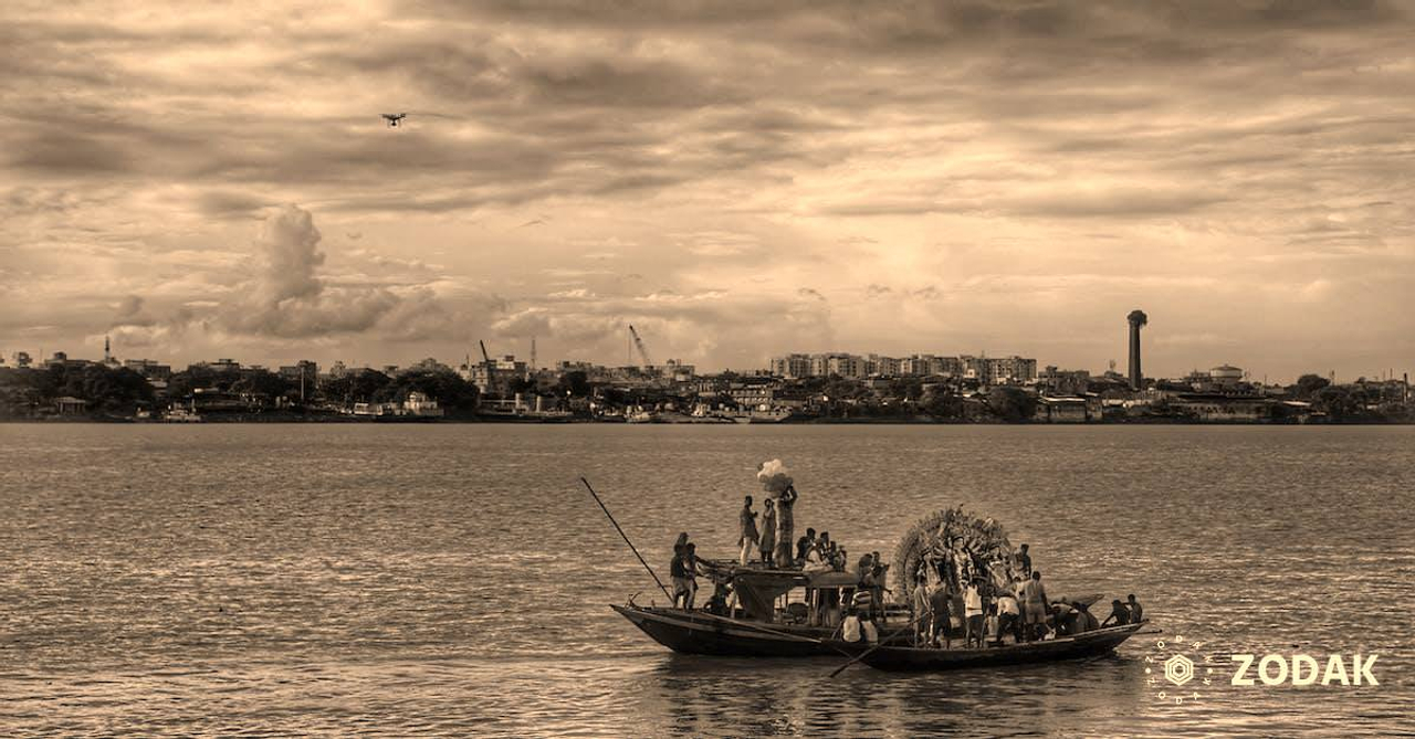 People in Boats Traversing a River