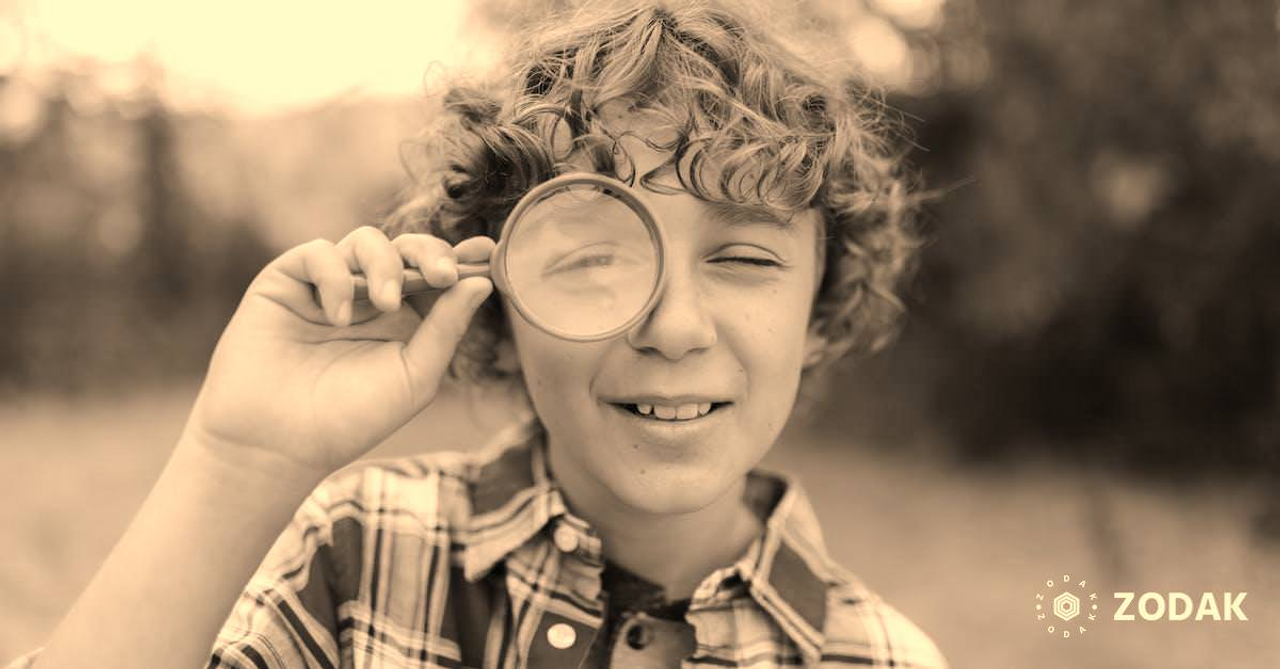 Boy with Curly Hair Looking Through a Magnifying Glass on His One Eye