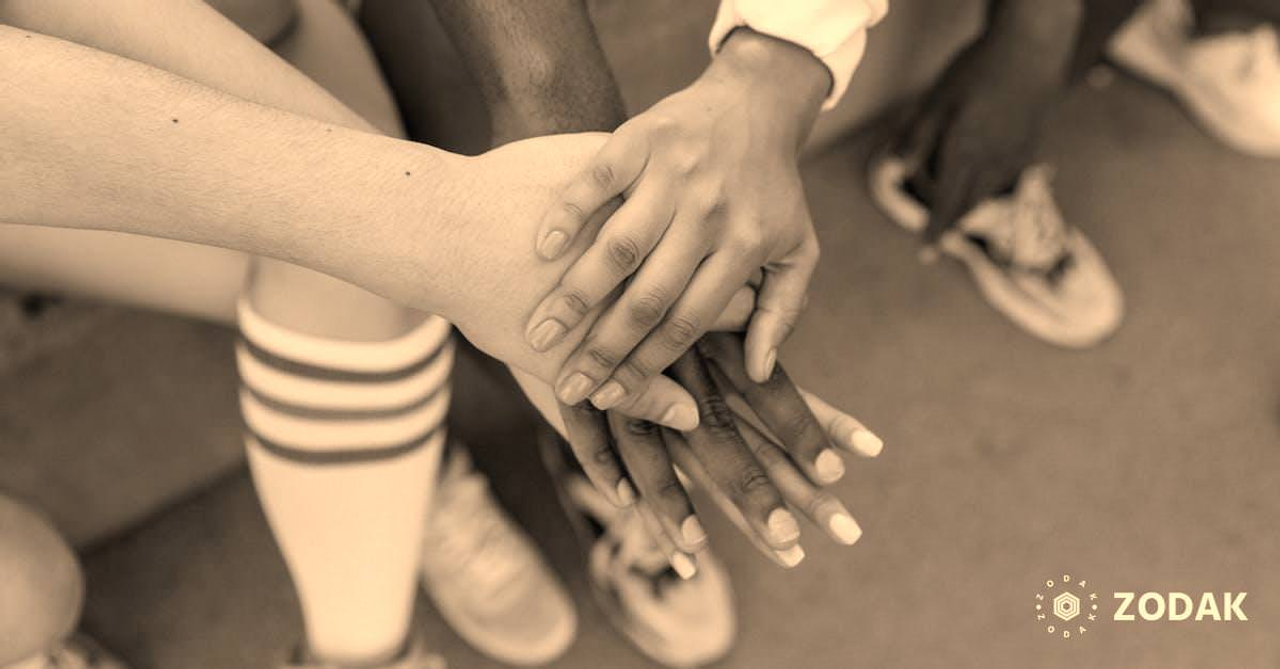 Faceless multiracial sport team stacking hands on court