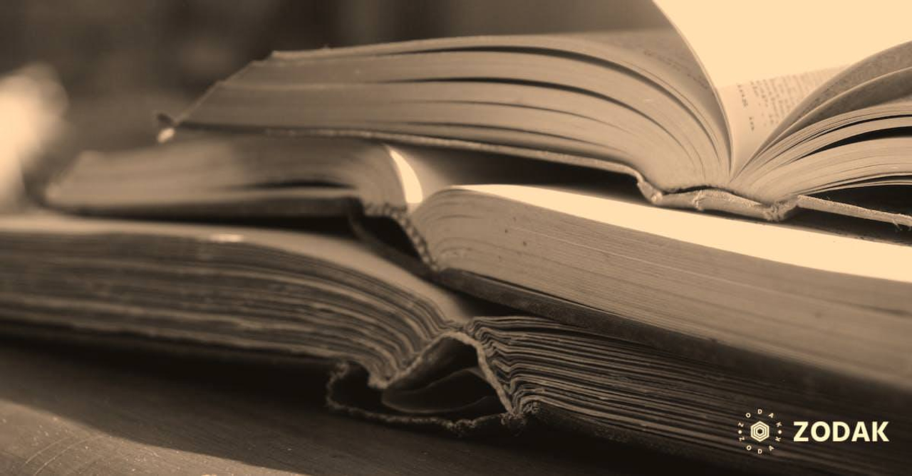 Closeup stack of opened books in hardcover placed on wooden table on sunny terrace