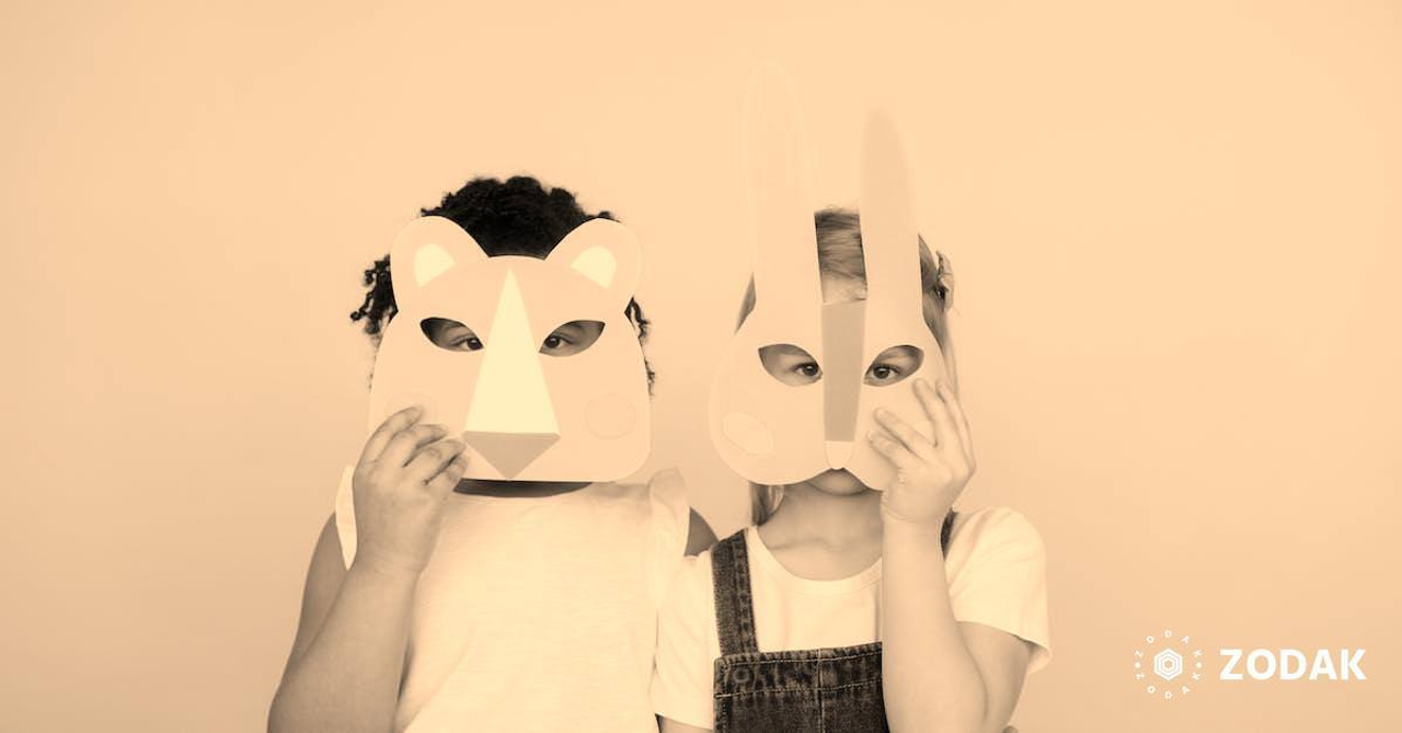 Two Kids Covering Their Faces With a Cutout Animal Mask