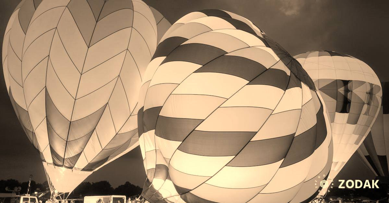 Group of people preparing bright air balloons to fly